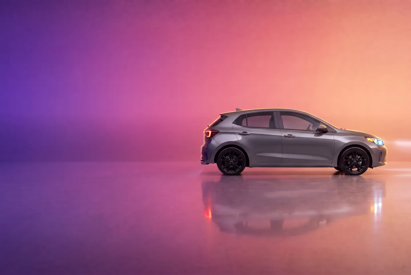 The same hatchback fixed: glossy paint, headlights on, no smoke, against a vivid violet-to-peach backdrop